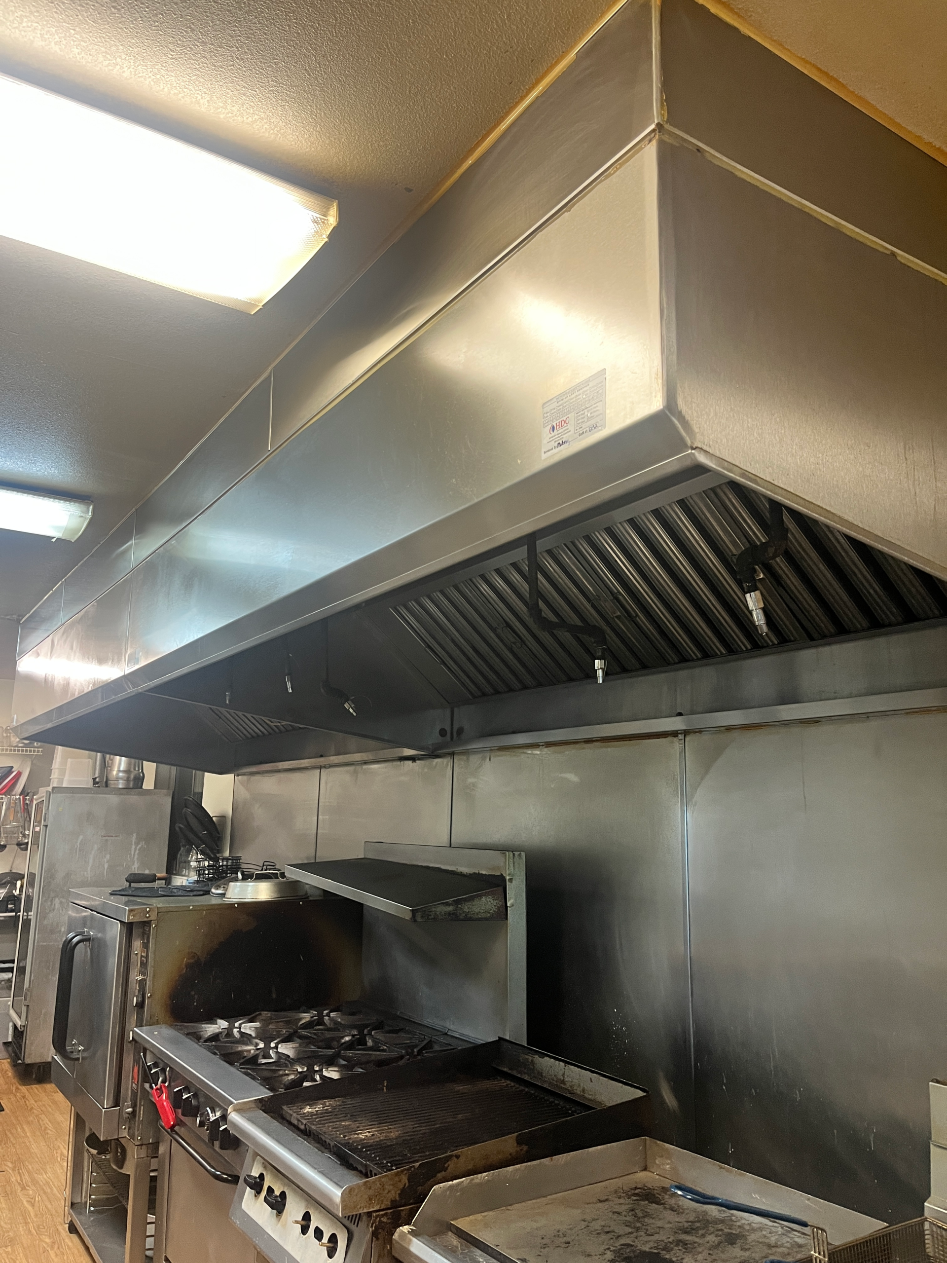 Commercial kitchen hood cleaned for safety compliance