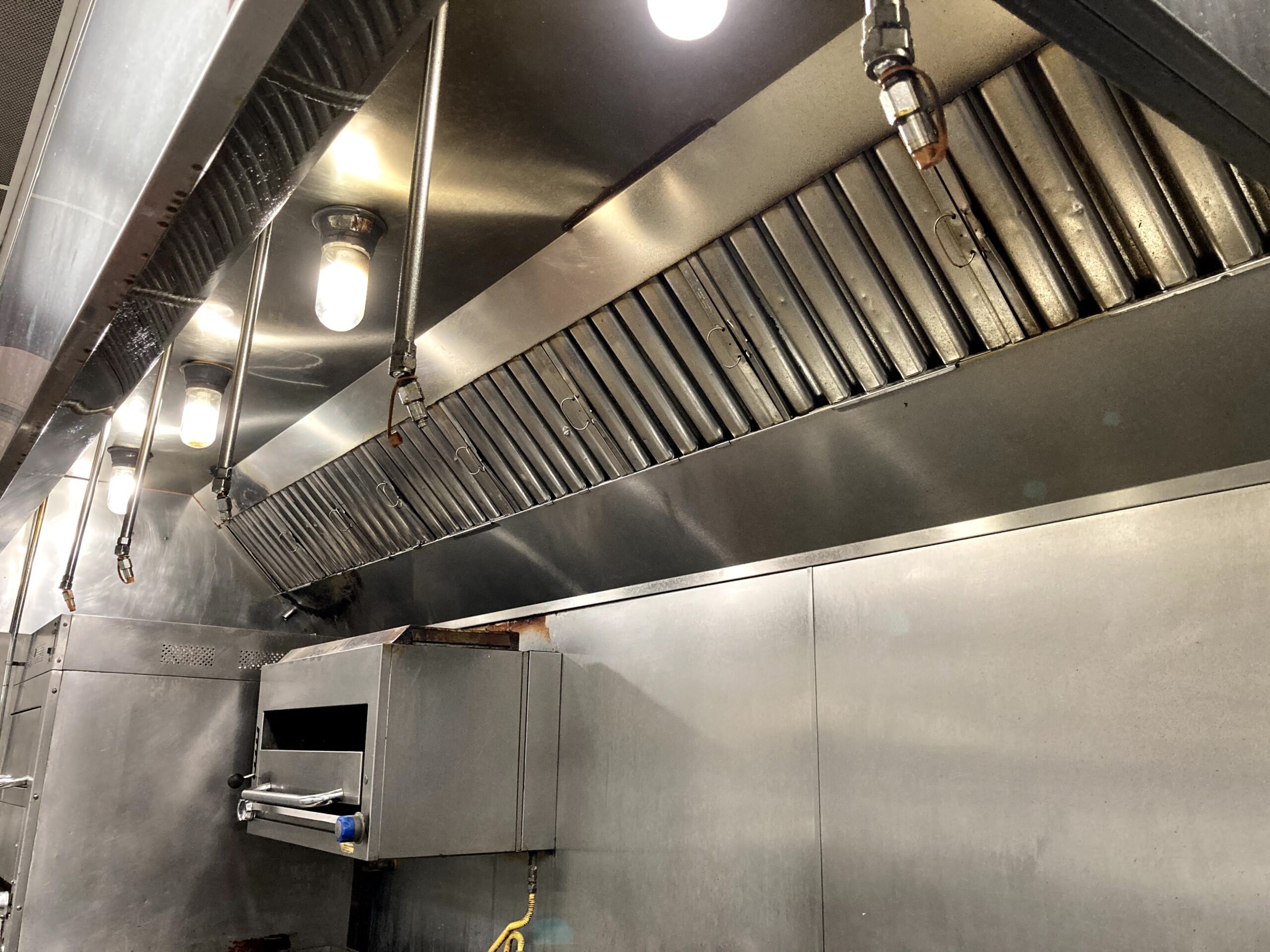 Commercial range hood cleaned and polished in restaurant kitchen